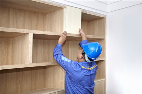 左右手家具安装师傅正在处理客户家进行家具保养